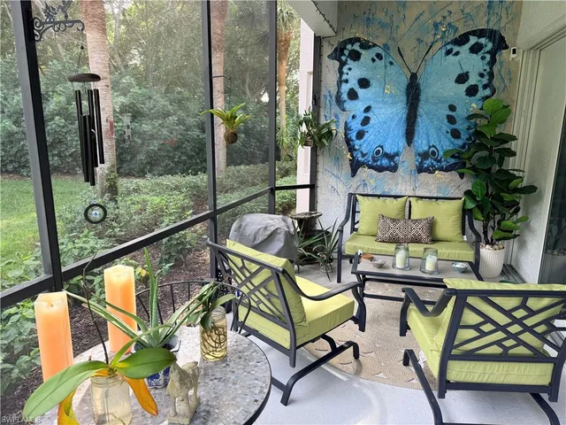 a balcony with couple of chairs and a potted plant