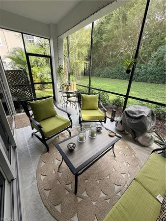 a living room with patio furniture and a floor to ceiling window