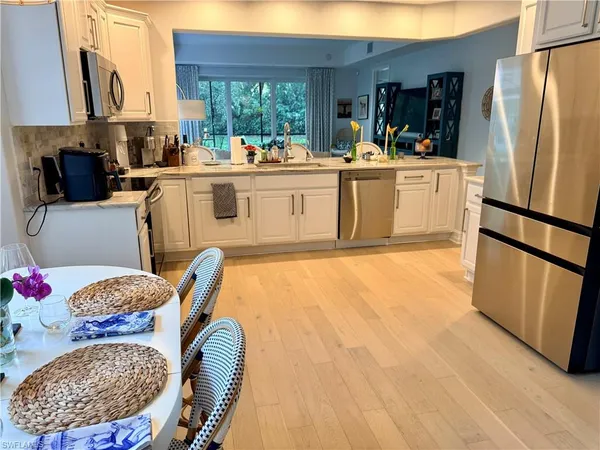 a living room with a table chairs and a refrigerator