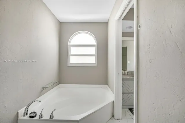 a white bath tub sitting in a bathroom next to a window