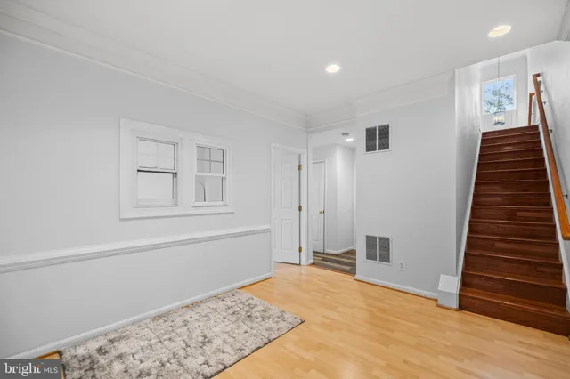 a view of a livingroom with wooden floor and stairs
