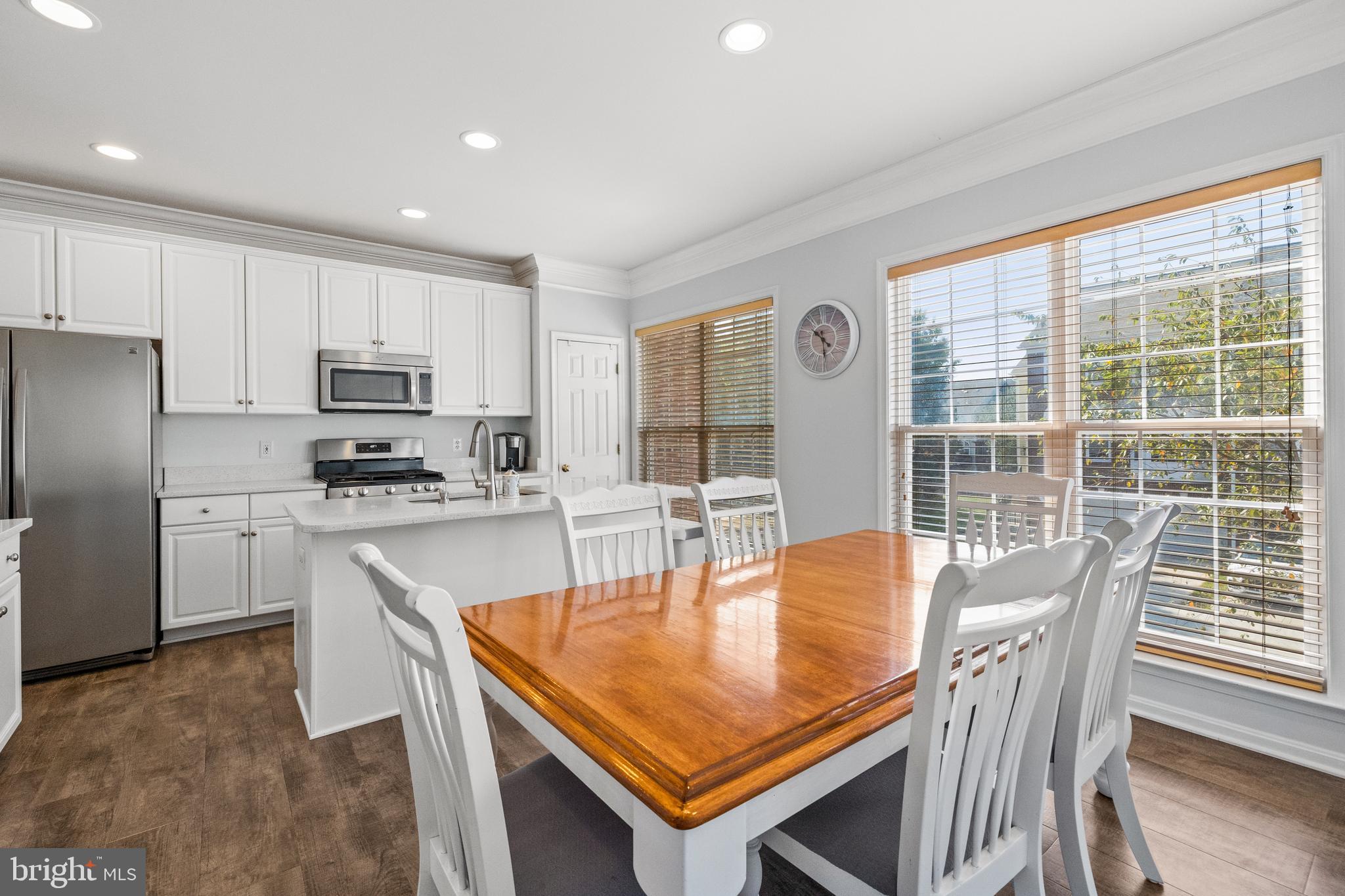 15016 Danube Way Haymarket, VA 20169 - Photo 5 of 22 a kitchen with stainless steel appliances granite countertop a stove a refrigerator a sink a dining table and chairs