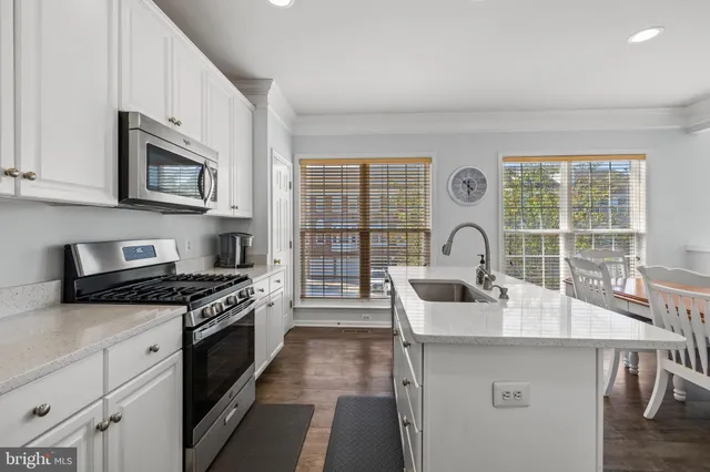 a kitchen with stainless steel appliances a stove a sink and a microwave