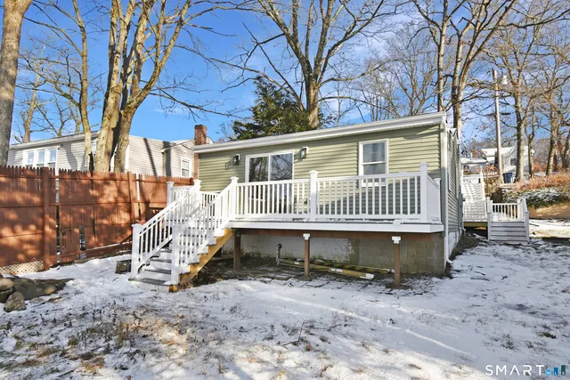 a small house with a bench and trees