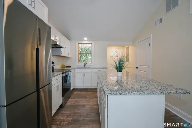 a kitchen with stainless steel appliances granite countertop a refrigerator sink and cabinets
