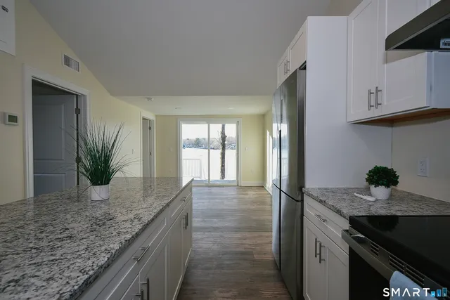 a kitchen with granite countertop a sink and a stove