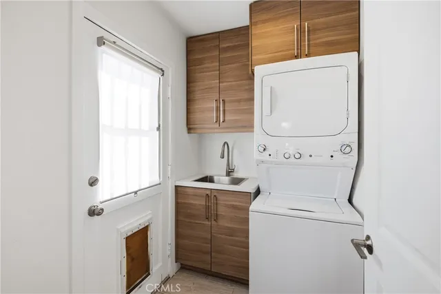 a view of washer and dryer with bathroom in the background