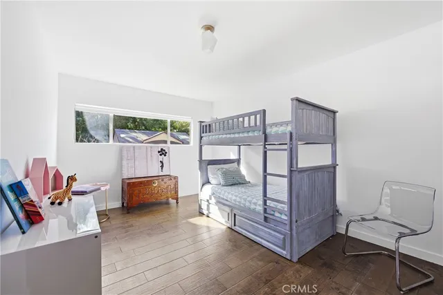 a bedroom with furniture and wooden floor
