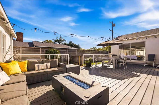 a roof deck with couches and wooden floor
