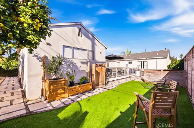 a view of a house with backyard and sitting area