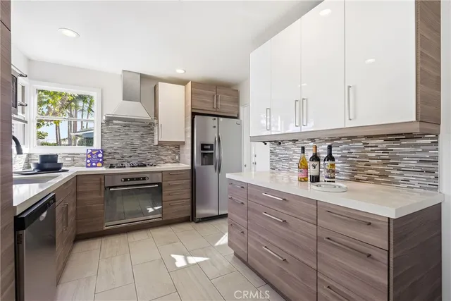 a kitchen with stainless steel appliances granite countertop a stove a sink and a refrigerator