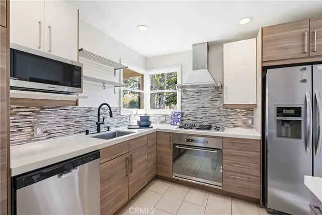 a kitchen with stainless steel appliances granite countertop a sink stove and refrigerator