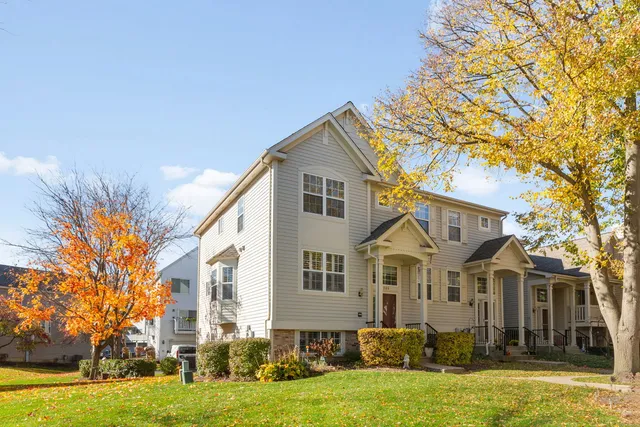 a front view of a house with a yard and trees