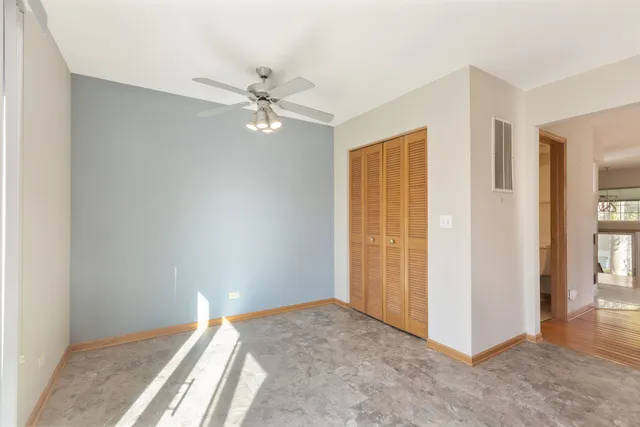 a view of a big room with closet and a chandelier fan