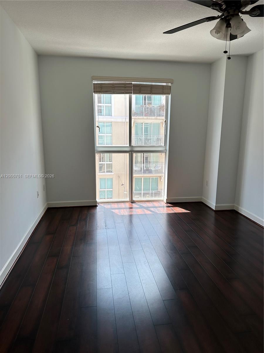 7275 Southwest 90th Street, Unit C408 Miami, FL 33156 - Photo 4 of 4 a view of an empty room with wooden floor and a window