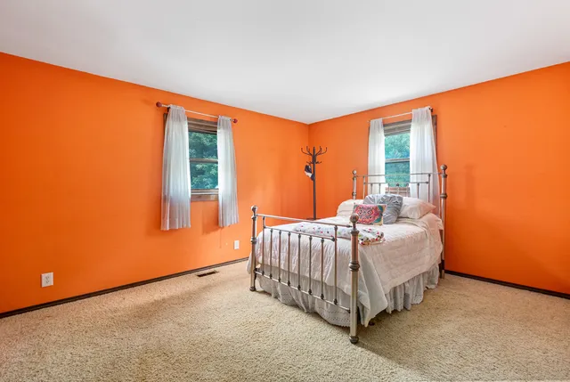 a bed sitting in a bedroom next to a window