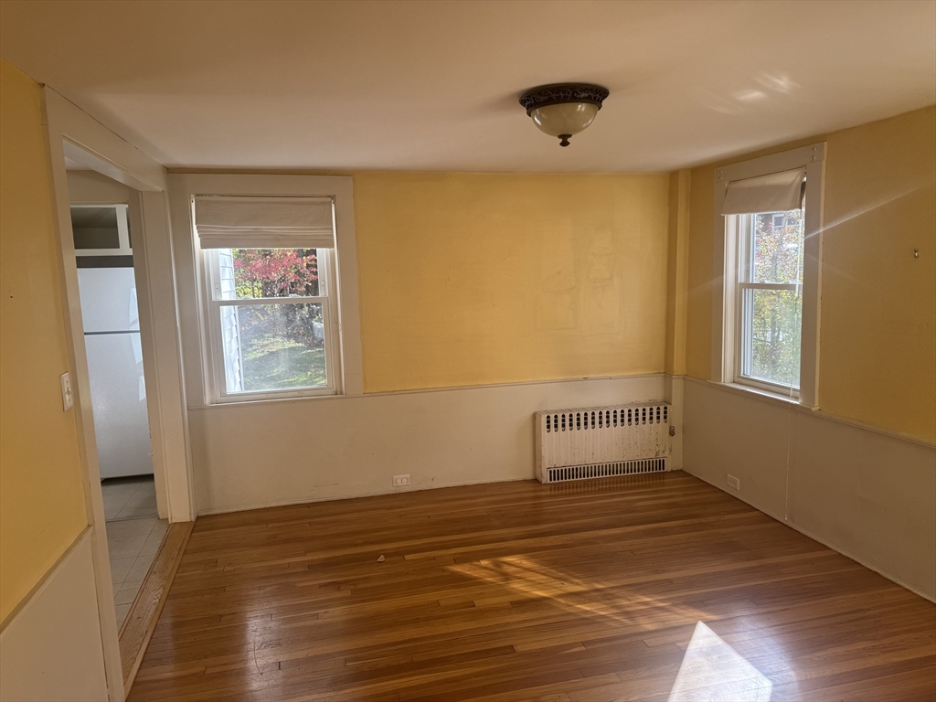 5 Curve Street, Unit 1 Lexington, MA 02420 - Photo 5 of 10 a view of an empty room with wooden floor and a window
