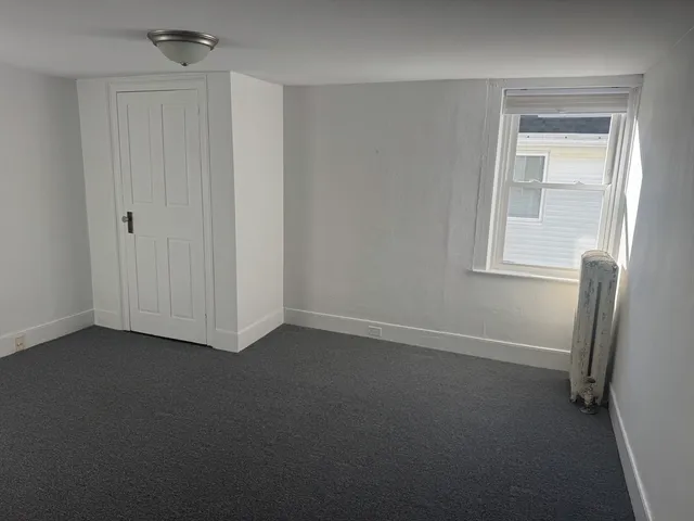 a view of empty room with window and fireplace