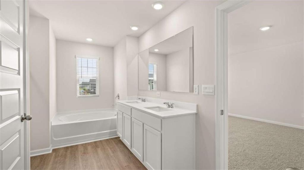 438 Abbott Road Statham, GA 30666 - Photo 17 of 56 a bathroom with a double vanity sink a mirror and a bathtub