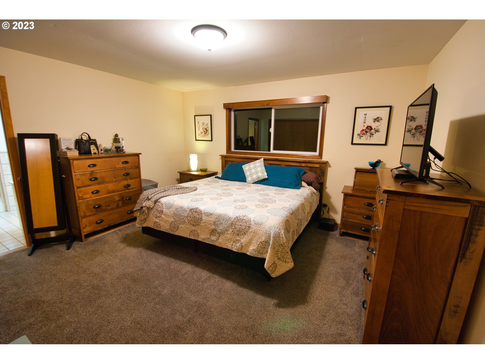 8181 Labish Center Road Northeast Silverton, OR 97381 - Photo 28 of 43 a bedroom with a bed and a flat tv screen on dresser