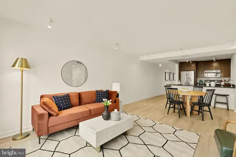 a living room with furniture a rug and kitchen view