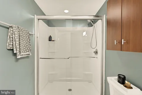 a bathroom with a shower and a glass door