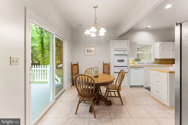 a kitchen with a dining table chairs and refrigerator