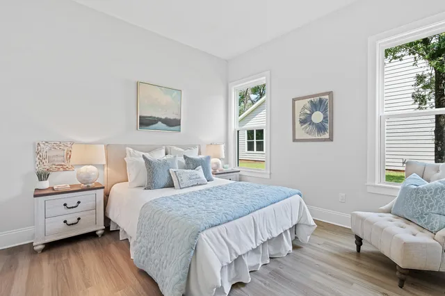 a living room with furniture large window and wooden floor