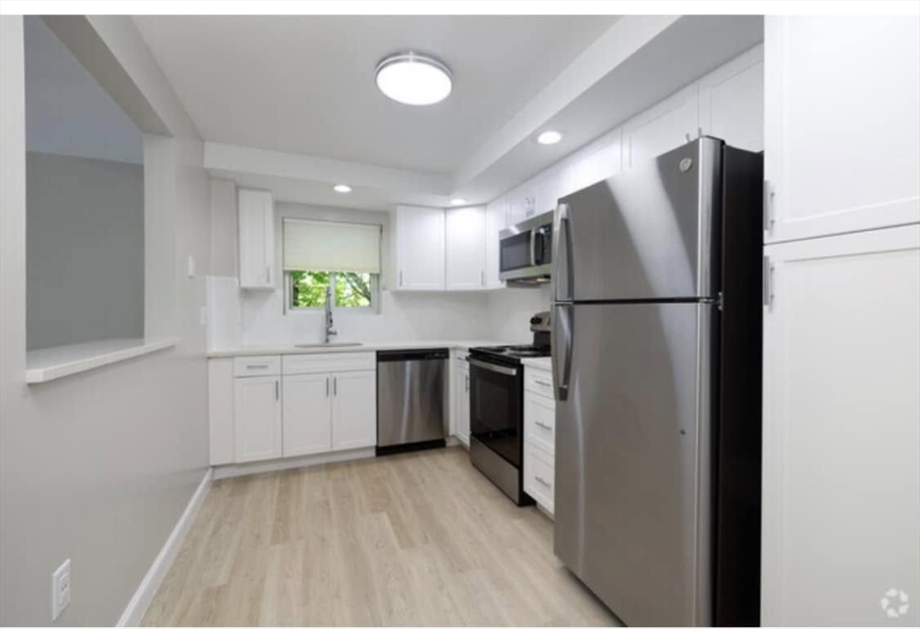 7 Stonehill Drive, Unit 1B Stoneham, MA 02180 - Photo 2 of 21 a kitchen with a refrigerator a sink and dishwasher
