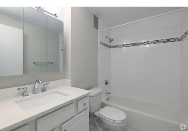 a bathroom with a sink mirror and shower
