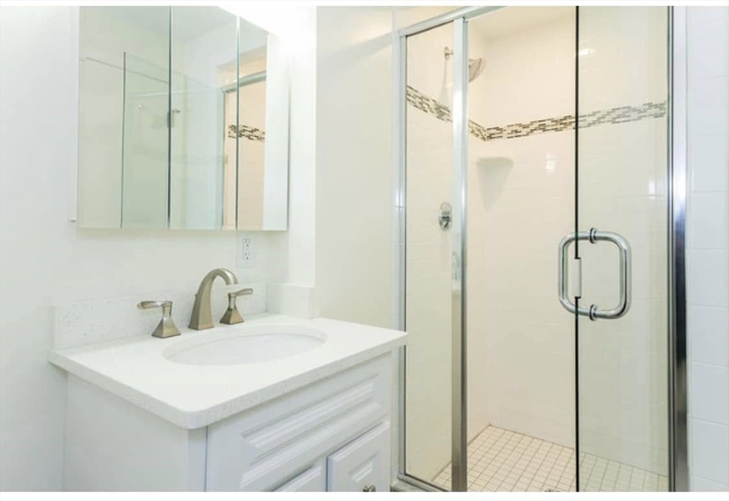 7 Stonehill Drive, Unit 1B Stoneham, MA 02180 - Photo 8 of 21 a bathroom with a sink mirror and shower