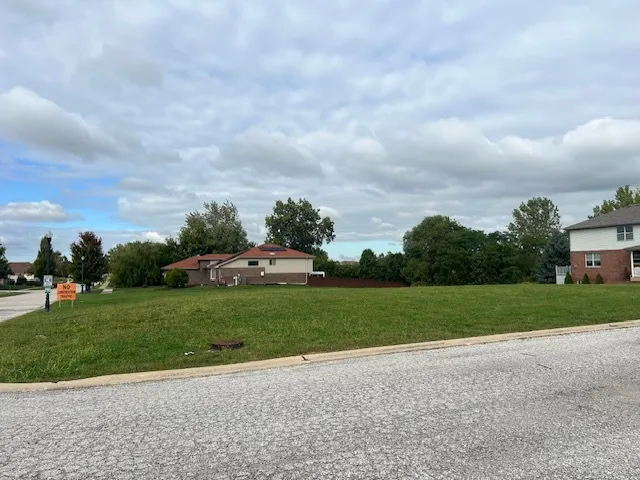 a view of a house with a big yard and a large trees
