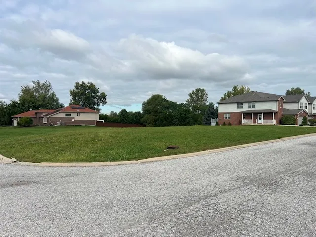 a view of a house with a big yard and large trees
