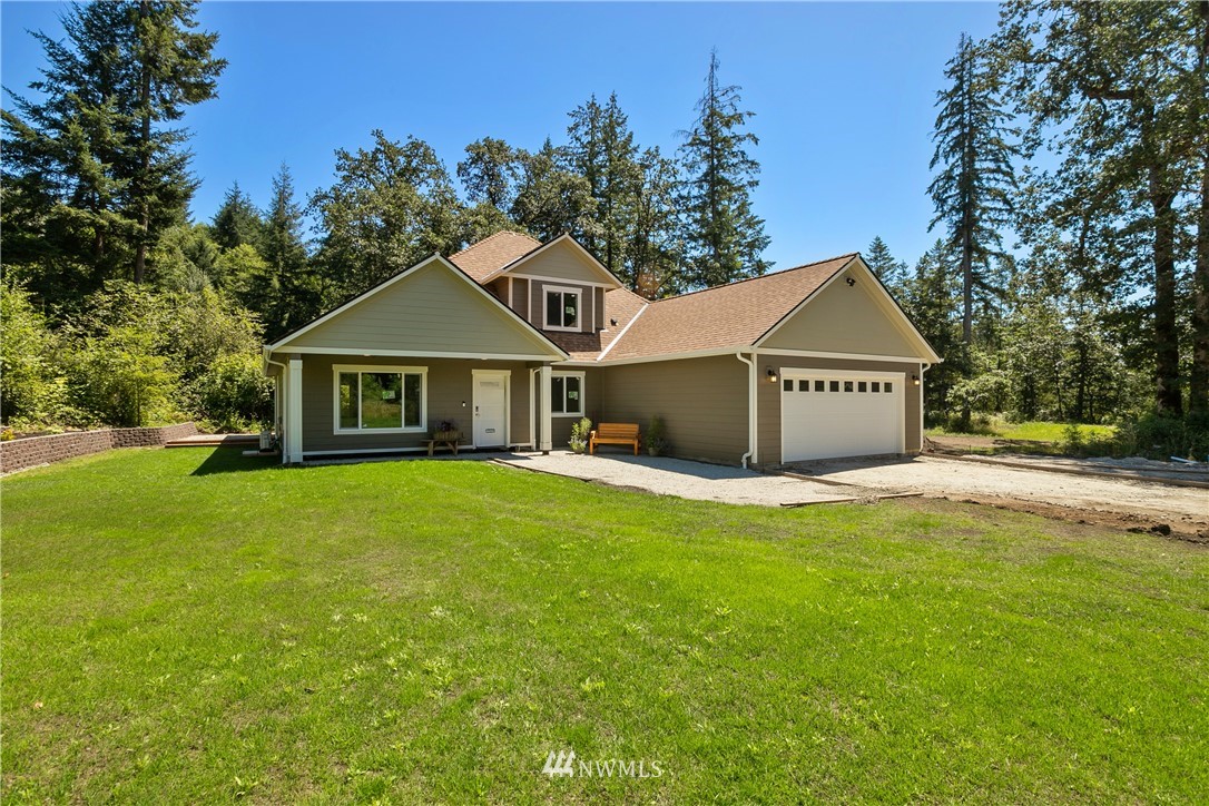 7907 175th Avenue Southwest Rochester, WA 98579 - Photo 2 of 39 a front view of a house with a yard and tree s
