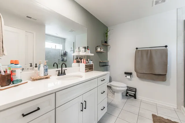 a spacious bathroom with a sink a toilet and mirror