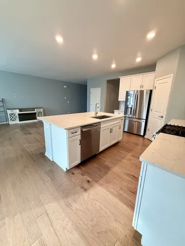 a large kitchen with stainless steel appliances a large counter top