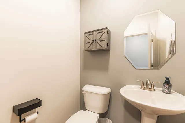 a bathroom with a toilet sink and mirror