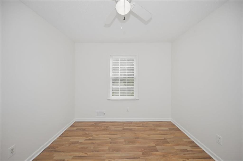 1496 Cherry Hill Road Southwest Conyers, GA 30094 - Photo 19 of 32 a view of an empty room with wooden floor and a window
