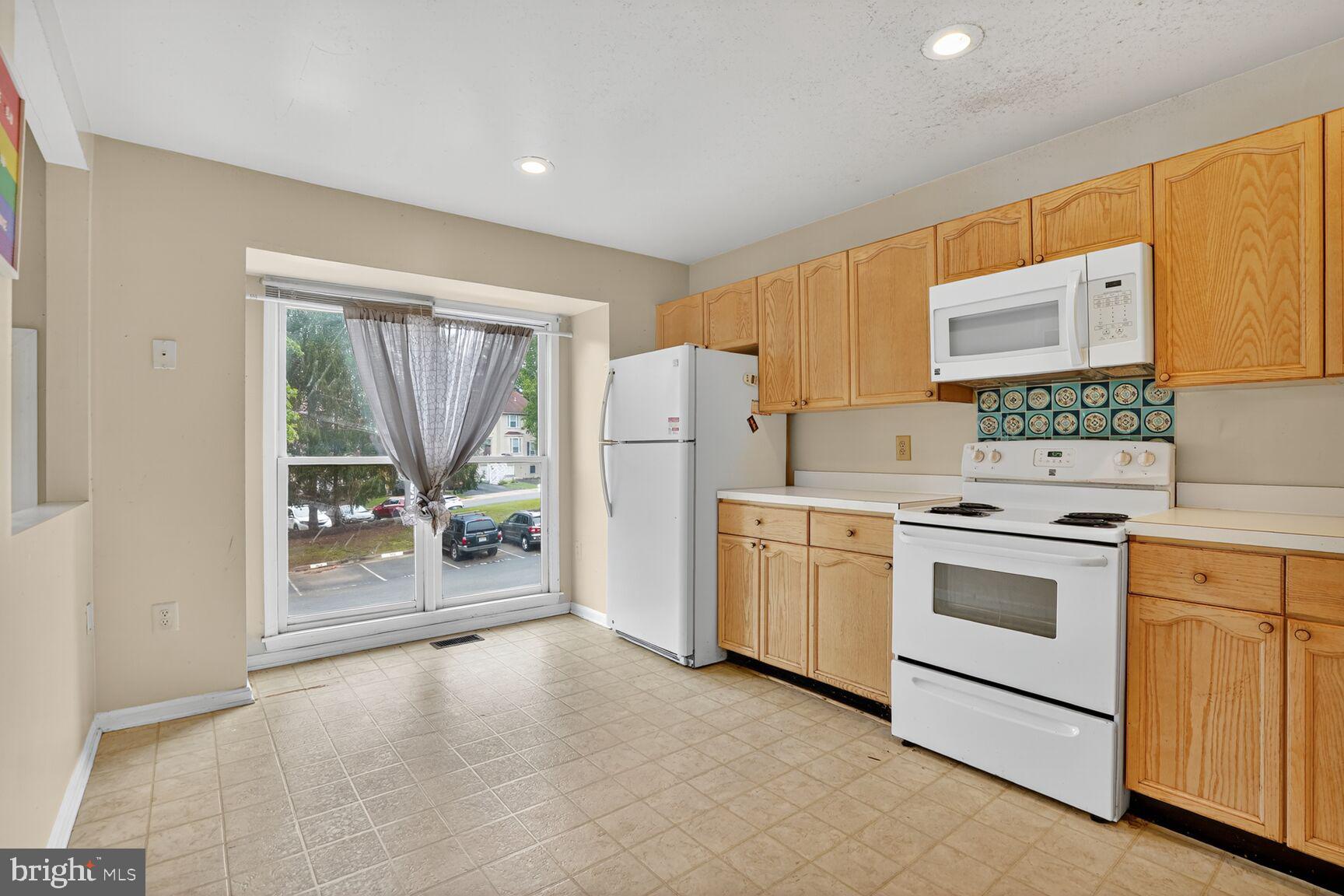 13920 Baton Rouge Court Centreville, VA 20121 - Photo 5 of 24 a kitchen with white cabinets and white appliances