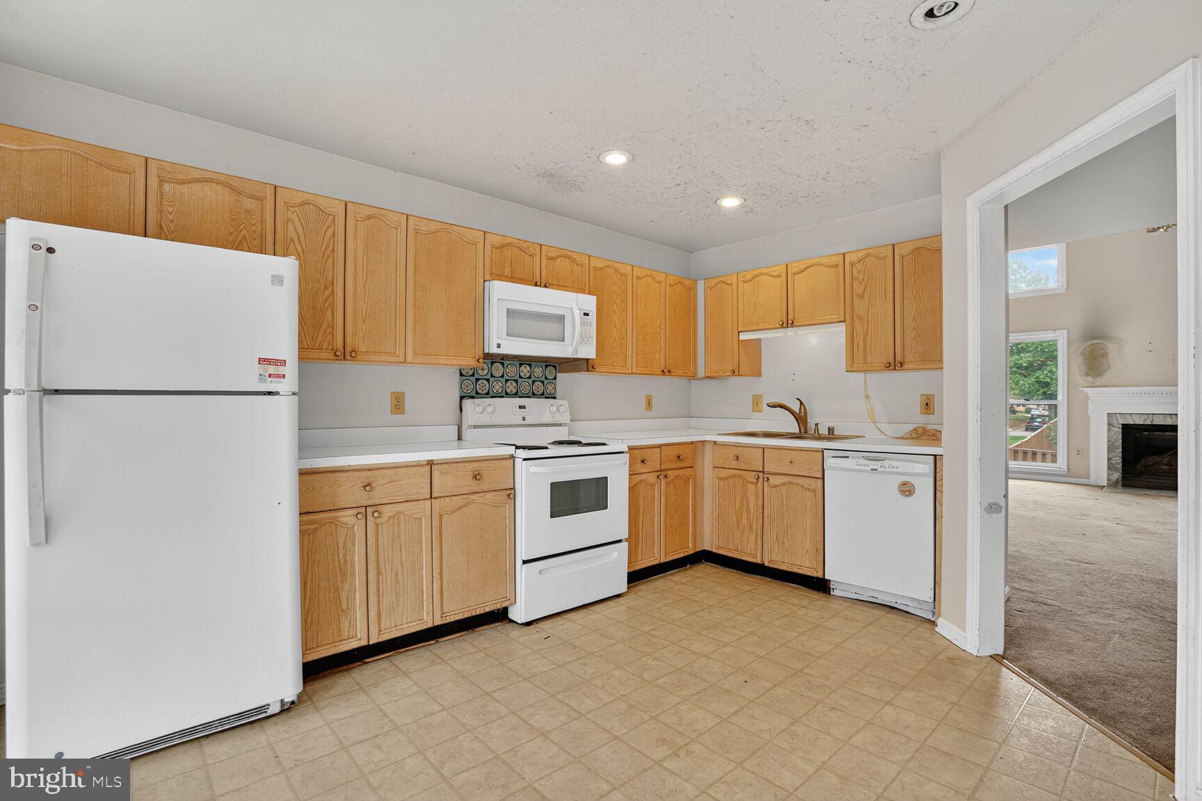 13920 Baton Rouge Court Centreville, VA 20121 - Photo 7 of 24 a kitchen with white cabinets and white appliances