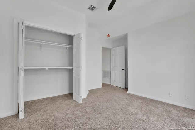 a view of an empty room with a ceiling fan