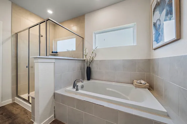 a bathroom with a tub a sink and mirror