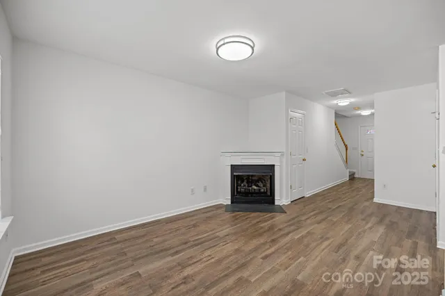 a view of empty room with wooden floor and fireplace