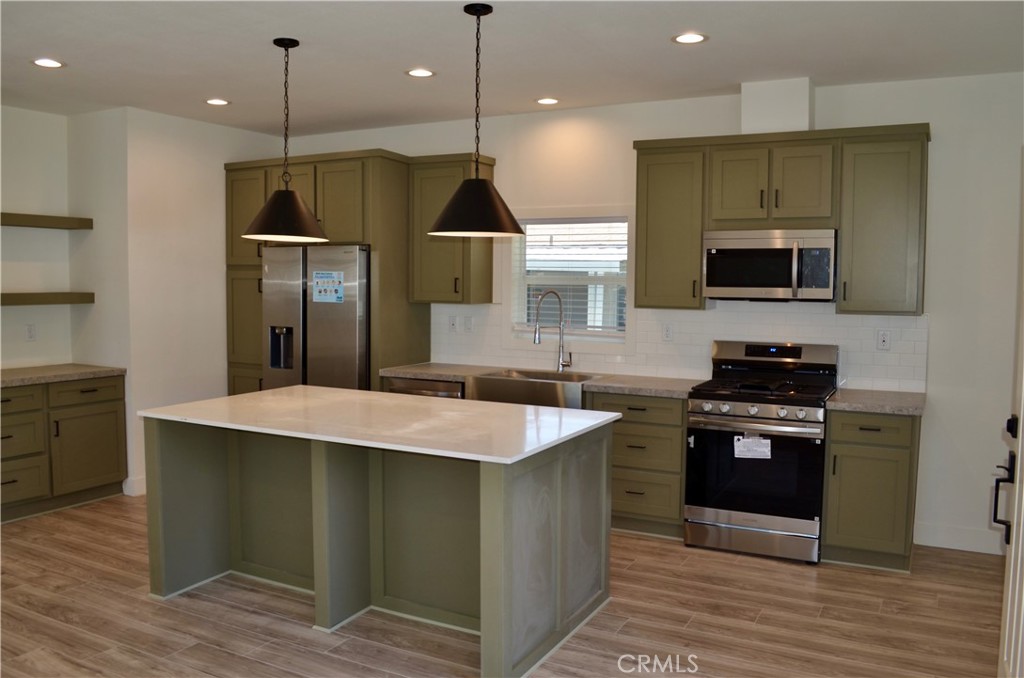 1226 Main Street, Unit 31 Cambria, CA 93428 - Photo 16 of 52 a kitchen with kitchen island a stove and a wooden floor