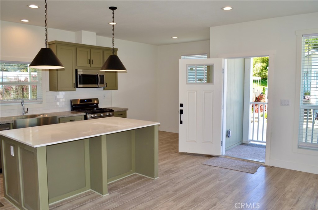 1226 Main Street, Unit 31 Cambria, CA 93428 - Photo 17 of 52 a kitchen with a stove and a wooden floor