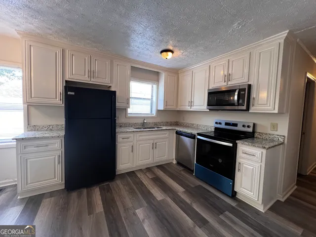 a kitchen with a refrigerator stove and sink