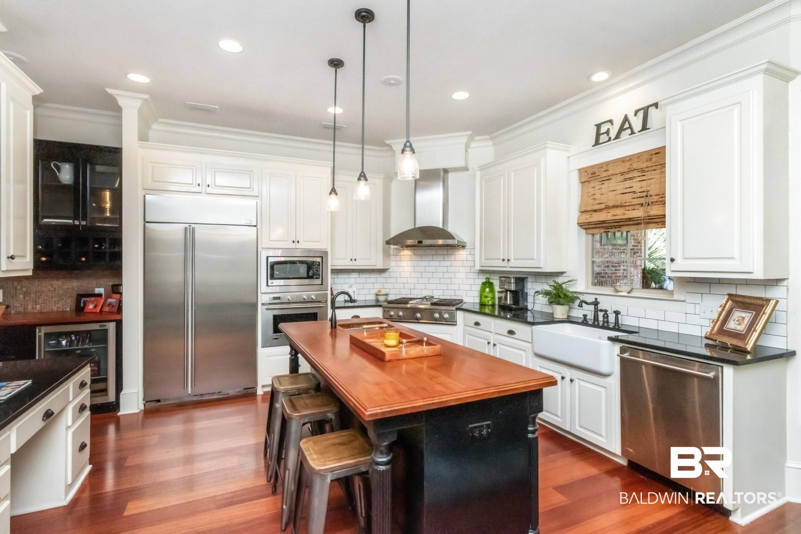8868 Dawes Lake Road South Mobile, AL 36619 - Photo 12 of 35 Kitchen with wall chimney range hood, a center island with sink, white cabinetry, built in appliances, and sink