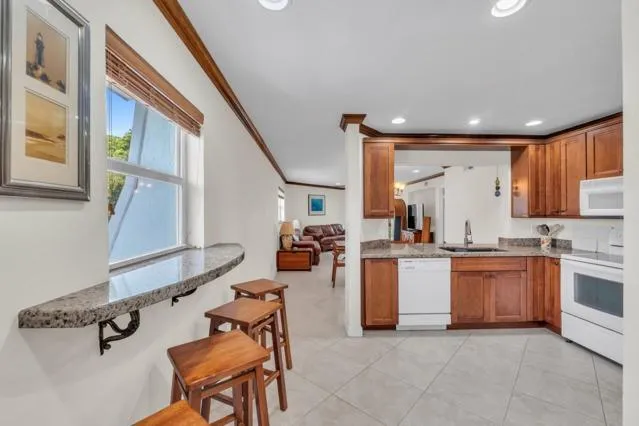 a kitchen with stainless steel appliances granite countertop sink stove and refrigerator