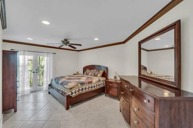 a spacious bedroom with a bed a mirror and windows