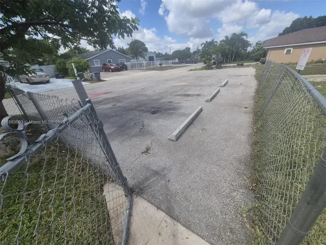 a view of a dry yard with wooden fence